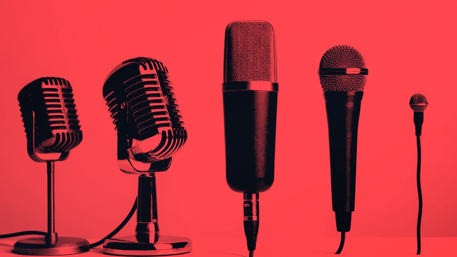Five microphones of different types and eras in a row, lit in red